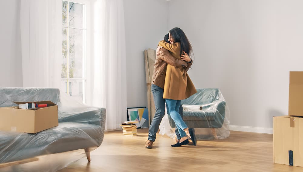A couple celebrates by dancing in their brand new living room